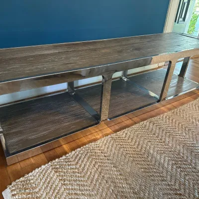 Contemporary low media console or bench featuring polished chrome framing with gray-washed wood shelves.
