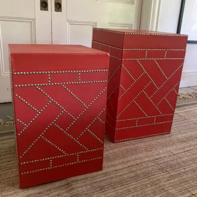 Pair of red faux-leather storage pedestals or trash cans featuring nailhead trim in a geometric lattice design.