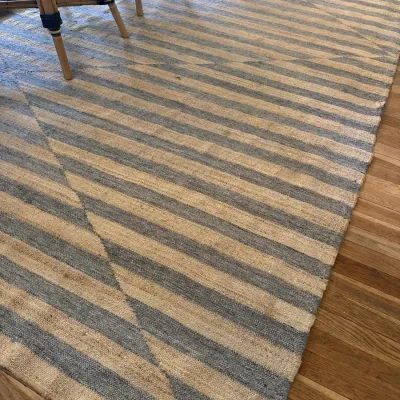 Large contemporary woven flatweave area rug featuring a blue and natural tan striped chevron design.
