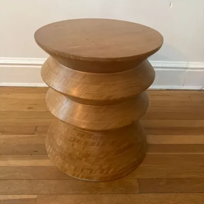 Sculptural wooden accent stool or end table, featuring a tiered, geometric hourglass silhouette with a parquet-style veneer finish.