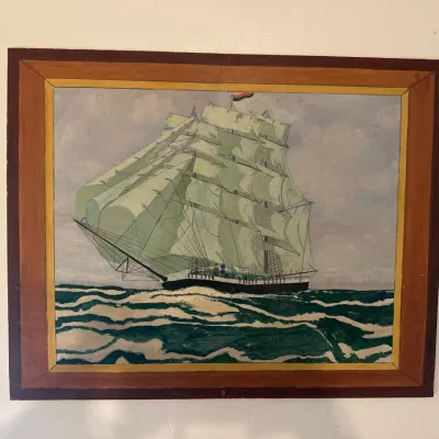 Framed folk art painting of a tall sailing ship at sea, set in a multi-toned wood frame.