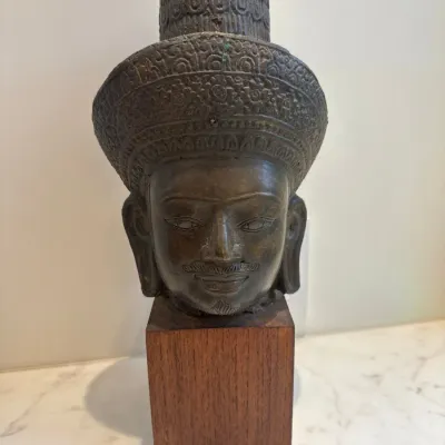 Sale Photo Thumbnail #52: Southeast Asian style patinated bronze head sculpture featuring intricate ornate headdress detail, mounted on a square wooden display block.