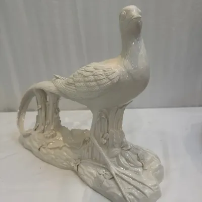 Sale Photo Thumbnail #30: Vintage white glazed ceramic pheasant figurine depicting a long-tailed bird perched on a botanical base.