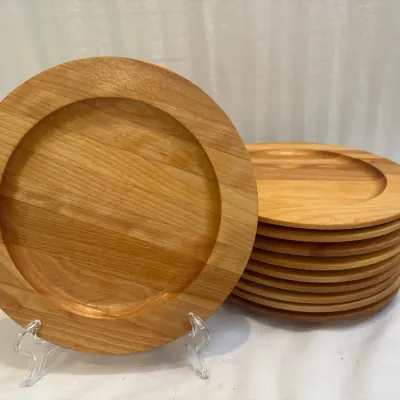 Sale Photo Thumbnail #50: Set of eight handcrafted wooden charger plates or serving dishes, featuring natural wood grain and wide rims.