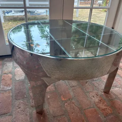 Sale Photo Thumbnail #31: Vintage Round chrome coffee table with a paneled glass top, featuring a polished metallic frame and tapered legs, circa 1970s.