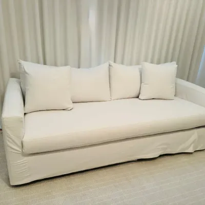Sale Photo Thumbnail #12: Contemporary white slipcovered sofa with a single long seat cushion and matching throw pillows.