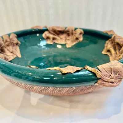 Sale Photo Thumbnail #53: Handcrafted studio pottery bowl featuring a glossy deep green glazed interior and applied sculpted leaf accents along the rim.