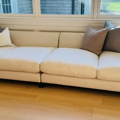 Sale Photo Thumbnail #2: Large contemporary cream fabric sectional sofa styled with coordinated neutral and gray throw pillows.