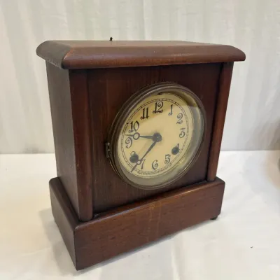 Sale Photo Thumbnail #29: Antique New Haven Clock Co. wooden mantle clock with an off-white dial and stylized Arabic numerals.