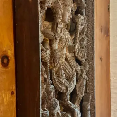 Sale Photo Thumbnail #34: Intricately hand-carved wooden wall panel featuring high-relief depictions of South Asian or Hindu deities mounted on wood paneled wall.