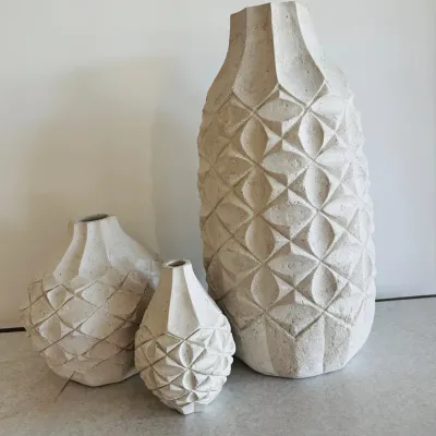 Sale Photo Thumbnail #15: Set of three off-white textured ceramic vases featuring carved geometric diamond patterns in varied sizes.