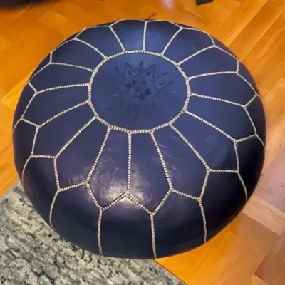 Sale Photo Thumbnail #36: Round navy blue Moroccan leather pouf ottoman with white contrast embroidery and an embossed star design on top.