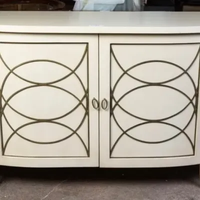 Sale Photo Thumbnail #9: Off-white painted demilune sideboard featuring geometric brass fretwork overlay on four cabinet doors.