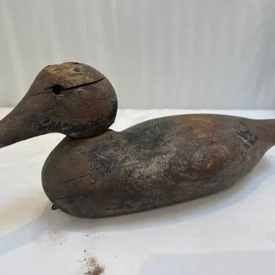 Sale Photo Thumbnail #51: Antique hand-carved wooden duck decoy featuring a weathered patina and visible splitting in the wood.