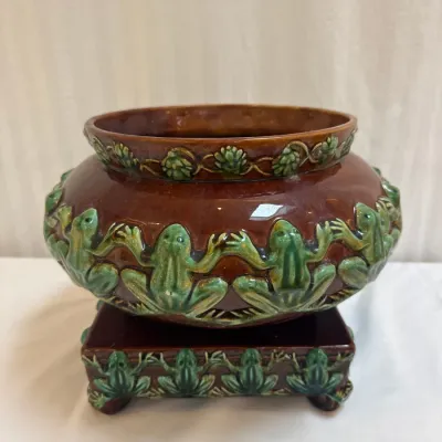 Sale Photo Thumbnail #55: Antique Majolica ceramic planter and matching square base, featuring relief-molded green frogs on a glossy brown glaze background.