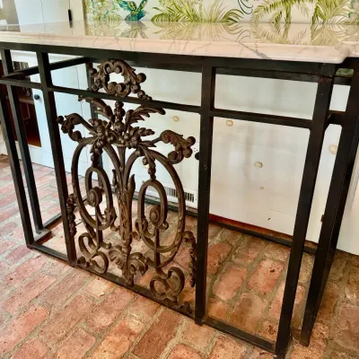 Sale Photo Thumbnail #25: Wrought iron console table featuring an ornate central scrollwork panel and a polished white marble top.