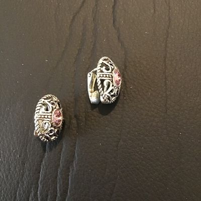 Sale Photo Thumbnail #153: Pair of Vintage Avon silver-tone clip-on earrings featuring detailed filigree scrollwork, beaded texture borders, and center-set oval pink rhinestones. In good pre-owned condition with functional clip backs and minor wear consistent with age and use.