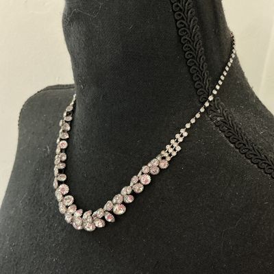 Sale Photo Thumbnail #232: Silver-tone collar necklace featuring set clear sparkly rhinestones in a cascading V-shape design along the front. Features a single strand of rhinestones along the back with a lobster claw clasp and adjustable extension chain. Appears to be in good pre-o
