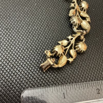 Sale Photo Thumbnail #28: Vintage Coro gold-tone link bracelet featuring textured leaf designs set with colorful, iridescent Aurora Borealis multi-color rhinestones and small accent stones. The fold-over clasp is marked with the Coro copyright logo. Shows light vintage wear consis