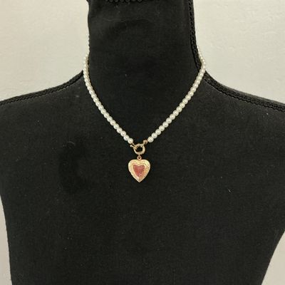 Sale Photo Thumbnail #215: Faux pearl strand necklace featuring a gold-tone, scroll-embossed heart locket attached by a front toggle clasp. The heart locket opens to hold a small photo. The back features a lobster claw clasp with an adjustable extender chain. Good overall condition