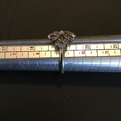 Sale Photo Thumbnail #209: Vintage-style marcasite cluster statement ring featuring an intricate floral/starburst design set with marcasite accents and a central stone. Shown on a ring mandrel measuring approximately size 9.5 (US size 9 1/2). Good pre-owned condition with light sur