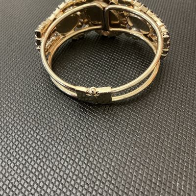Sale Photo Thumbnail #18: A statement vintage hinged bangle bracelet featuring deep purple/amethyst-colored prong-set rhinestones and large faceted center stones set in a gold-tone metal frame. Has a secure spring-hinge clasp. Measures approximately 2.5 inches wide. Overall in ver