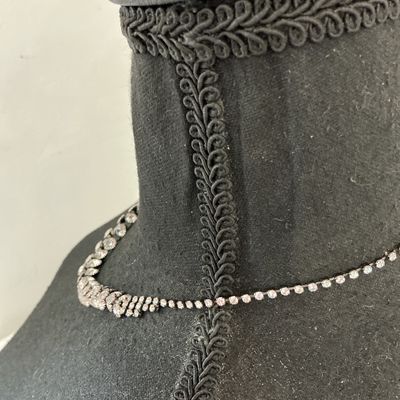 Sale Photo Thumbnail #233: Silver-tone collar necklace featuring set clear sparkly rhinestones in a cascading V-shape design along the front. Features a single strand of rhinestones along the back with a lobster claw clasp and adjustable extension chain. Appears to be in good pre-o