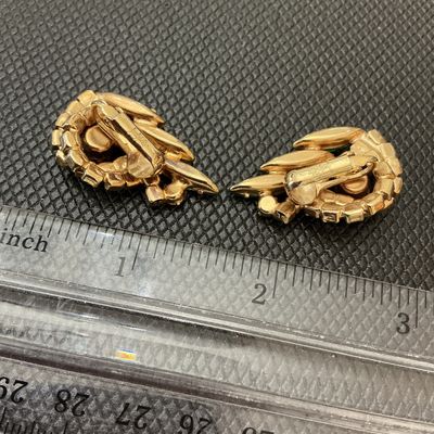 Sale Photo Thumbnail #63: Pair of vintage gold-tone clip-on earrings featuring multi-shade green rhinestones in swirl and marquise cuts. Measure approximately 1.25 inches long. Signed 'Judy Lee' on the clips. Light wear consistent with age, stones remain bright and intact.