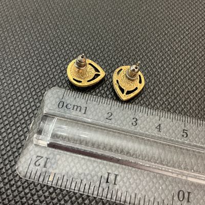 Sale Photo Thumbnail #190: Pair of vintage gold-tone pierced post earrings featuring a classic faux cameo portrait of a woman in profile set against a terracotta-colored background. The cameos are framed by detailed gold-tone openwork filigree teardrop settings. The backs display a