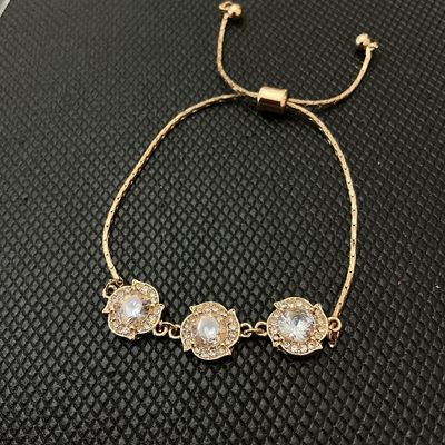 Sale Photo Thumbnail #156: Gold-tone adjustable slider/bolo style bracelet featuring three flower-shaped central stations set with clear faceted rhinestones and surrounded by smaller crystal accents. The adjustable slider bead allows for a customizable fit. Three main decorative el