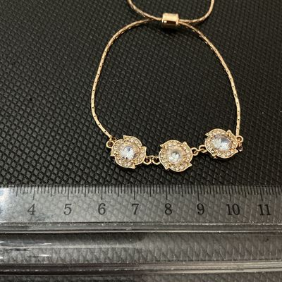 Sale Photo Thumbnail #160: Gold-tone adjustable slider/bolo style bracelet featuring three flower-shaped central stations set with clear faceted rhinestones and surrounded by smaller crystal accents. The adjustable slider bead allows for a customizable fit. Three main decorative el
