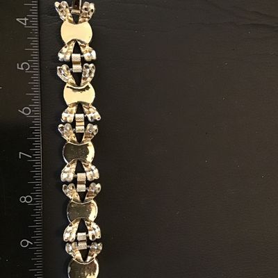 Sale Photo Thumbnail #197: Vintage silver-tone link bracelet featuring colorful textured glass or ceramic cabochons in green, pink, red, yellow, and blue, framed by decorative bow-like metal links. Measures approximately 7 inches in length. Features a fold-over clasp. Good vintage 