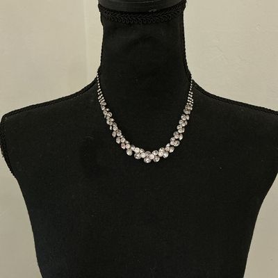 Sale Photo Thumbnail #222: Silver-tone collar necklace featuring set clear sparkly rhinestones in a cascading V-shape design along the front. Features a single strand of rhinestones along the back with a lobster claw clasp and adjustable extension chain. Appears to be in good pre-o
