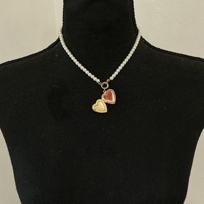 Sale Photo Thumbnail #220: Faux pearl strand necklace featuring a gold-tone, scroll-embossed heart locket attached by a front toggle clasp. The heart locket opens to hold a small photo. The back features a lobster claw clasp with an adjustable extender chain. Good overall condition