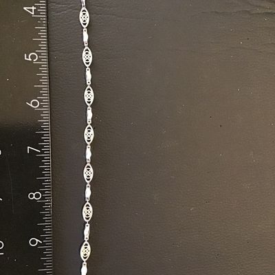 Sale Photo Thumbnail #245: Silver-tone link chain bracelet featuring delicate openwork filigree oval links interspersed with polished Bar links. Measures approximately 7 inches long with a lobster claw clasp. Good condition with light surface wear.