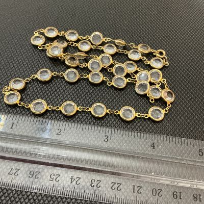 Sale Photo Thumbnail #83: Gold-tone chain station necklace featuring bezel-set round clear facetted crystals or glass stones. Secured with a spring ring clasp. In good pre-owned condition with minor signs of wear.