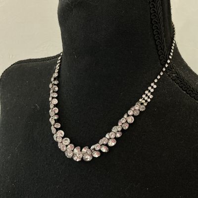 Sale Photo Thumbnail #226: Silver-tone collar necklace featuring set clear sparkly rhinestones in a cascading V-shape design along the front. Features a single strand of rhinestones along the back with a lobster claw clasp and adjustable extension chain. Appears to be in good pre-o