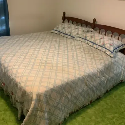 Traditional Wood Bed with Decorative Headboard & Bedding including mattress and box spring.