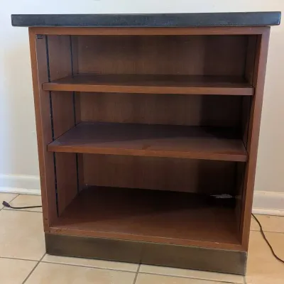 Sale Photo Thumbnail #30: Vintage wood veneer low bookcase with a dark laminate top, two adjustable shelves, and a plinth base.
