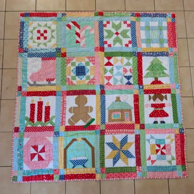 Sale Photo Thumbnail #46: Handmade Christmas patchwork and applique sampler quilt featuring holiday motifs including a gingerbread man, ice skate, nativity scene, and Christmas tree.