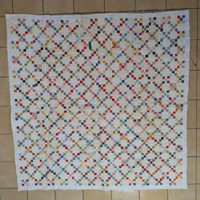Sale Photo Thumbnail #6: Handmade Irish Chain patchwork quilt featuring a colorful array of printed fabric squares on a white background, displayed on tiled flooring.