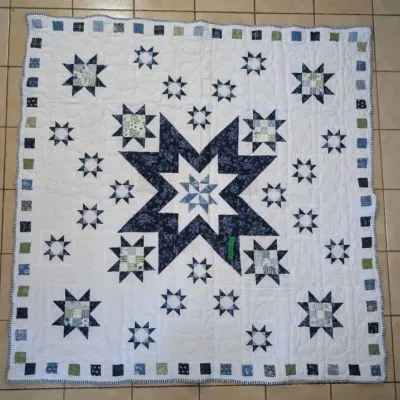 Sale Photo Thumbnail #26: Handmade patchwork star quilt featuring blue, green, and white printed fabrics with a pieced outer border.