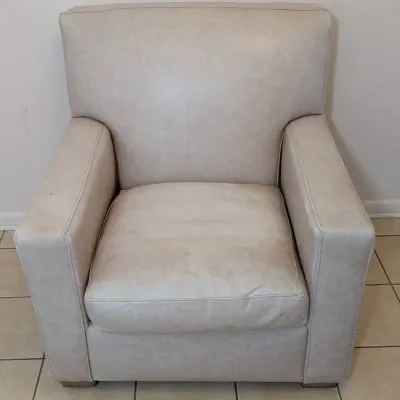 Sale Photo Thumbnail #33: Off-white faux leather armchair featuring wide block arms and a plush removable seat cushion.