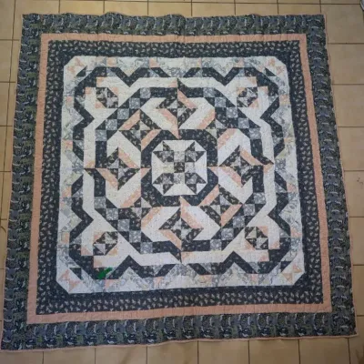 Sale Photo Thumbnail #24: Handmade patchwork quilt featuring intricate geometric labyrinth patterns in shades of navy blue, grey, white, and soft peach pink, complete with decorative printed borders.