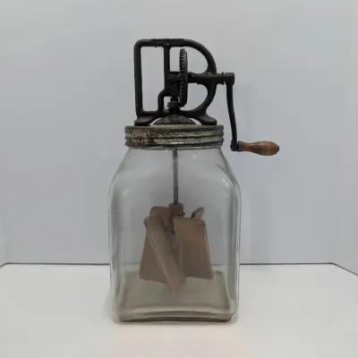 Sale Photo Thumbnail #62: Antique Dazey glass butter churn with cast iron hand-crank mechanism and internal wooden paddles.