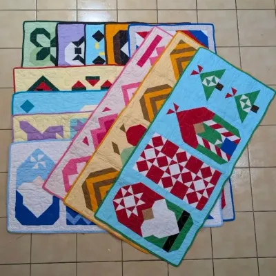 Sale Photo Thumbnail #4: Collection of handmade quilted table runners featuring various geometric and holiday patterns laid out on tiled floor.