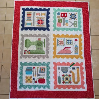 Sale Photo Thumbnail #18: Handmade sewing-themed patchwork quilt with colorful pieced blocks depicting thread, scissors, a sewing machine, and irons within scalloped borders.