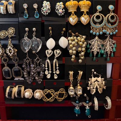 Collection of vintage costume earrings, including dangling, clip-on, and stud designs with faux pearls, rhinestones, and gold-tone accents.