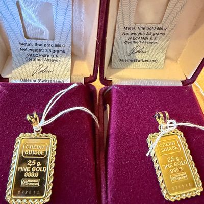 Sale Photo Thumbnail #21: Two Credit Suisse 2.5-gram 999.9 fine gold bullion ingots, framed as pendants and presented in original burgundy velvet display cases with Valcambi assay certificates.