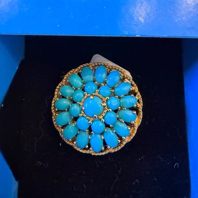 Sale Photo Thumbnail #24: Vintage gold-tone cluster ring set with bright turquoise cabochons arranged in a concentric flower design, presented in a blue jewelry box.